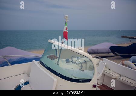 Windschutzscheibe des Bootes mit einer kleinen italienischen Flagge oben. Nahaufnahme des Bootes vor dem Hintergrund des Meeres. Stockfoto