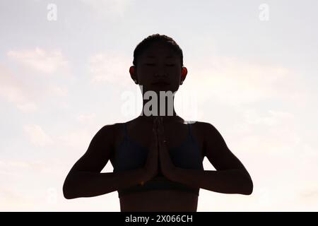 Frau, die Yoga in Gebetsposition praktiziert Stockfoto