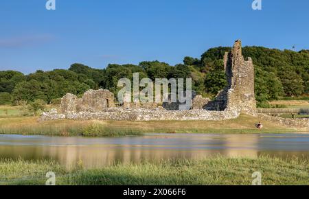 Ogmore Castle, Eine Ruine der normannischen Burg in der Nähe von Bridgend, Südwales. Die Burg spiegelt sich auf dem glatten Wasser des Flusses Ogmore. Stockfoto