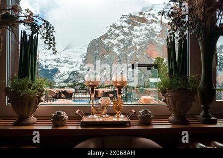 Gemütliches Innenleben mit Blick auf die schneebedeckten Berge durch das Fenster Stockfoto