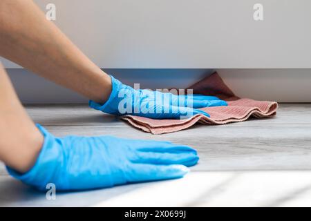 Hausfrau in Gummihandschuhen wäscht zu Hause den Boden. Frau, die zu Hause nass reinigt. Hochwertige Fotos Stockfoto