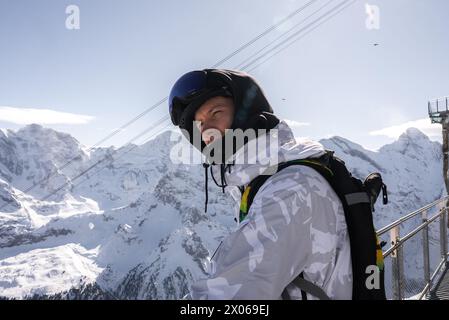 Person in weißer Jacke und Helm im Skigebiet Murren, Blick auf die Schweizer Alpen Stockfoto