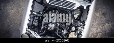 Draufsicht des Fahrzeugmotors. Öffnen Sie die Motorhaube mit detaillierten Autokomponenten. Stockfoto