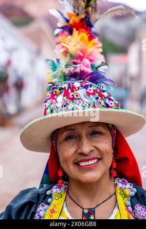 Eine einheimische Frau in Einem bunten Kostüm posiert für Ein Foto auf dem Kunsthandwerksmarkt in Purmamarca, Provinz Jujuy, Argentinien. Stockfoto