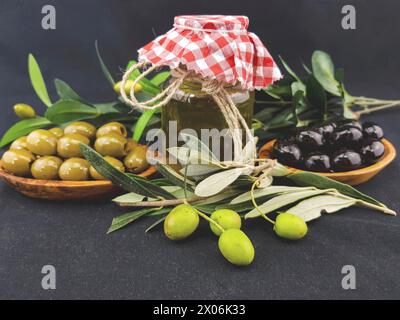 Frische und eingelegte Oliven und ein Glas Olivenöl Stockfoto