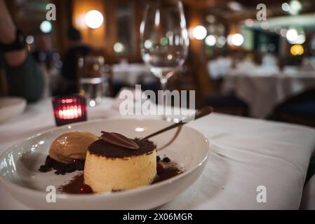 Luxuriöse Dessertpräsentation mit Flan und Eis auf weißem Teller, Zermatt Restaurant Dining Scene Stockfoto