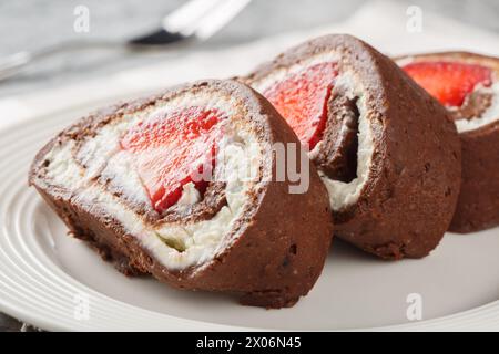 Stückchen Schokoladenkuchen mit Erdbeeren und Frischkäse auf einem Teller. Horizontal Stockfoto