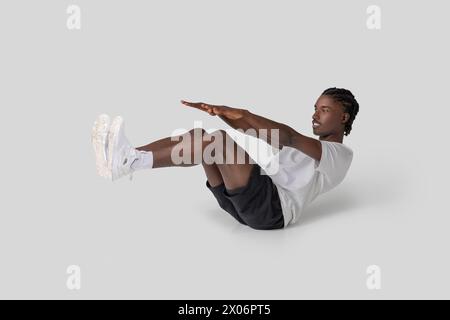Mann, der eine V-Sit-Bauchübung auf weißem Hintergrund durchführt Stockfoto