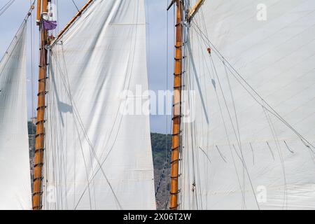 White Dacron segelt auf einem klassischen hölzernen Segelboot mit Holzmasten. Segeln vor der Küste. Stockfoto