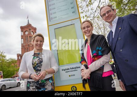 Berlin, Deutschland. April 2024. Franziska Giffey (l-r, SPD), Senatorin für Wirtschaft, Manja Schreiner (CDU), Senatorin für Verkehr, und Henrik Falk, CEO der BVG, präsentieren Sie die erste digitale Lichtsäule der BVG an der Bushaltestelle Rotes Rathaus. Anstelle von Fahrplänen und Informationen auf Papier werden die Anzeigen jetzt Informationen über die Abfahrtszeiten liefern. In diesem Jahr sollen insgesamt 80 Säulen online gehen. Quelle: Jörg Carstensen/dpa/Alamy Live News Stockfoto