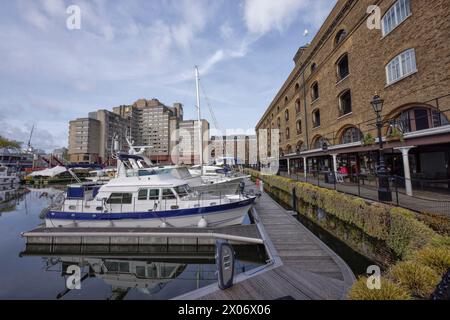 Boote im Yachthafen St. Kathrine's Dock am Ivory House mit Geschäften, Cafés, Restaurants und Wohnhäusern an der Themse in Tower Hamlets, London. Stockfoto