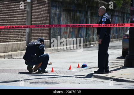 Polizisten des Chicagoer Polizeidezernats markieren, wo Granathüllen und andere Beweisgegenstände an einem Tatort gefunden wurden, bei dem einer verletzt und ein anderer tot war. Zwei Menschen wurden erschossen, einer starb am helllichten Tag in Chicago, Illinois, USA. Ein 41-jähriger Mann und ein 33-jähriger Mann waren am Dienstag Morgen gegen 11:16 Uhr draußen im Block 6900 der N. Glenwood Avenue, als sich ein unbekannter Täter näherte und anfing, Schüsse in ihre Richtung abzufeuern. Das 41-jährige männliche Opfer erlitt eine Schusswunde auf dem Rücken und wurde in gutem Zustand und in das Krankenhaus gebracht Stockfoto