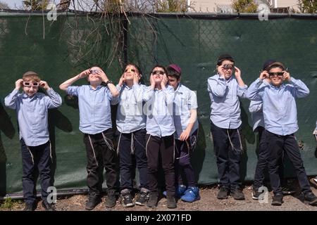 Eine Gruppe von 7 orthodoxen jüdischen Jungen beobachtet die Sonnenfinsternis 2024 vom Schulhof ihrer Jeschiwa aus. Im Rockland County, New York. Stockfoto