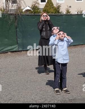 2 Jeschiwa-Schüler und ein Lehrer an ihrer Schule beobachten die Sonnenfinsternis 2024. Im Rockland County, New Yiork. Stockfoto