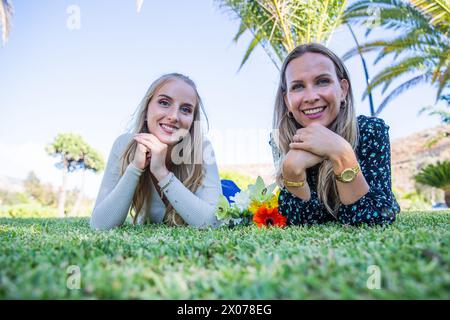 Mutter und Tochter liegen lächelnd auf dem Gras, Familienkonzept Stockfoto