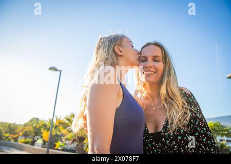 Die Tochter gibt ihrer Mutter einen Kuss auf die Stirn, Liebe zwischen Tochter und Mutter Stockfoto