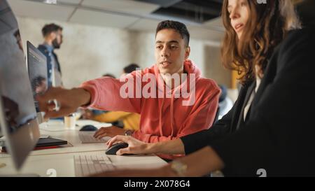 Verschiedene multiethnische Gruppen von weiblichen und männlichen Schülern sitzen im College Room und arbeiten an Schulprojekten am Computer zusammen. Junge Wissenschaftler lernen, sprechen, wenden akademische Fähigkeiten und Wissen im Unterricht an. Stockfoto