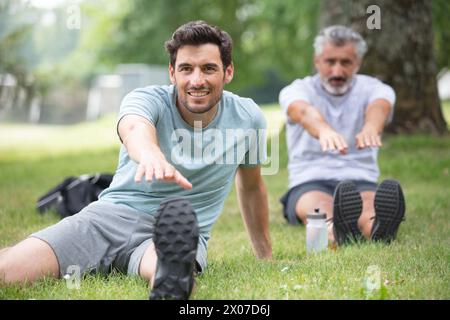 Zwei Männer sitzen und trainieren im Garten Stockfoto