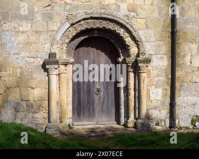 Die normannische Südtür von All Saints North Dalton mit ungewöhnlicher linker Hauptstadt von Halbfiguren unter Bögen Stockfoto