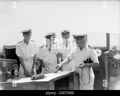 DIE MEERE WIEDER SICHER MACHEN. 1945. AUGUST AUF SEE IM GOLF VON GENUA. MIT DER 12. MINENRÄUMUNGSFLOTTE IM GOLF VON GENUA UNTER DEM KOMMANDO VON COMMANDER C SIMPSON, DSC, RN, COMMANDER MINENRÄUMUNG WESTITALIENS. SIE ARBEITEN AUF DER GRUNDLAGE VON KAPITULIERTEN FEINDKARTEN UND WERDEN VON SUPERMARINE WALROSSEFLUGZEUGEN UND DER US NAVY-ABSCHOTTUNG ZUR MINENBEOBACHTUNG UNTERSTÜTZT. - An Bord der HMS CIRCE. Auf der Brücke von links nach rechts: Sub Lieut G A Lawrence, RNVR, aus Hemel Hempstead; Lieut Cdr C D Abbott, DSC, RNR, aus Cardiff; Sub Lieut A L Ford RNVR aus Coventry; Lieut A J Beavis, RNVR aus London Stockfoto