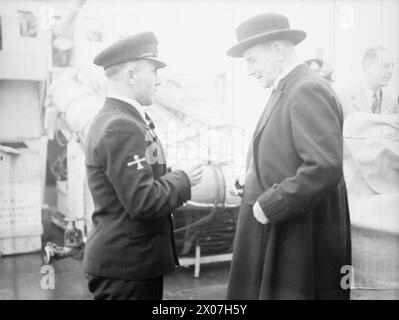 Bürger von Ely, Cambridgeshire, einschließlich des Dekans und der ratsmitglieder, besuchen ihren adoptierten Zerstörer der V- und W-Klasse HMS Walpole am 8. Dezember 1943 in Harwich; gezeigt wurde ein Anruf von Bosun durch den Kameraden des Chief Bosun. Stockfoto