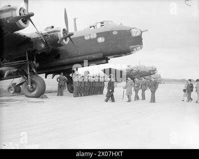 BOMBERKOMMANDO DER ROYAL AIR FORCE, 1939-1941. - Der Premierminister Winston Churchill und seine Partei nähern sich einer kurzen Stirling Mark I von der No. 7 Squadron RAF, deren Luft- und Bodenbesatzung zur Inspektion angereiht ist, während einer Überprüfung der britischen und amerikanischen Bomber, die bei der Rafat Northolt, Middlesex im Einsatz waren. Begleitet wird der Premierminister, aber von ihm verdeckt, von Air Chief Marshal Sir Charles Portal, Chief of the Air Staff, gefolgt von Sir Archibald Sinclair, Secretary of State for Air and Air Vice-Marshal Trafford Leigh-Mallory, Air Officer Commanding No. 11 Group, Fighter Command. Die Flugzeuglinie Stockfoto