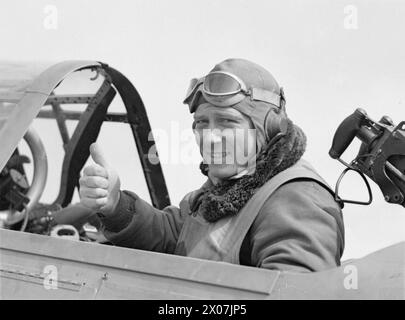 US-MARINEFLIEGER KOMMEN IN GROSSBRITANNIEN AN. APRIL 1942: ROYAL MARINEFLUGSTATION HATSTON. VIER GESCHWADER VON US NAVY, BESTEHEND AUS 9 DOUGLAS TBD DEVASTATOR TORPEDOBOMBERN, 9 GRUMMAN F4F WILDCAT JAGDFLUGZEUGEN UND 29 VOUGHT SB2U VINDICATOR SCOUT BOMBERN, KAMEN IN HATSTON AN, UM MIT DER FLOTTENLUFTWAFFE ZUSAMMENZUARBEITEN. MIT IHNEN SIND 65 US-MARINE-PILOTEN UND 200 ODD-RADIOMEN, LUFTWAFFENSCHÜTZER UND RESERVEN. - Radioman 1. Klasse C W Smith, im hinteren Cockpit seines Vought SB2U Vindicator Scout Bombers Stockfoto