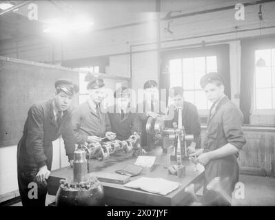 MÄNNER FÜR DIE FLOTTENLUFTWAFFE FÜR DIE ZUKUNFT. 15. UND 16. DEZEMBER 1943, ROYAL AIR TRAINING ESTABLISHMENT, NEWCASTLE-UNDER-LYME. JUNGE BRITEN, DIE SICH AUF EINEN WICHTIGEN JOB VORBEREITEN, JUNGEN AB 15 JAHREN, DIE FÜR DIE FLOTTENFLUGWAFFE TRAINIEREN. - Lehrlinge studieren die Kurbelwelle eines Flottenluftwaffenjägers Stockfoto