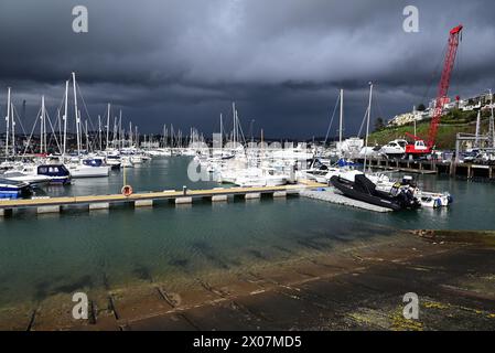 Sonnenschein und dunkle Wolken über Booten im Hafen von Torquay, wenn sich Regen nähert. Stockfoto