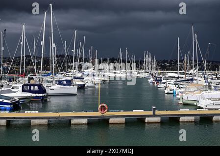 Sonnenschein und dunkle Wolken über Booten im Hafen von Torquay, wenn sich Regen nähert. Stockfoto