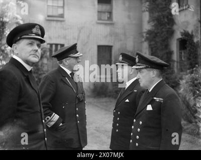 DER FÜNFTE SEE INSPIZIERT MARINE-LUFTFAHRTAUSBILDER. 22. JUNI 1945: ROYAL MARINEFLUGSTRAINESTATION IN NEWCASTLE-UNDER-LYME. DER FÜNFTE SEA LORD, KONTERADMIRAL T H TROUBRIDGE, CB, DSO UND BAR, FÜHRTE EINE AUSUFERNDE INSPEKTION VON MARINEFLUGZEUGEN DURCH. - Konteradmiral Troubridge spricht mit einem der Offiziere Stockfoto