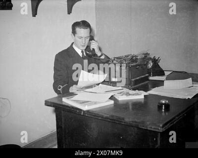 ZEITUNG DER BRITISCHEN PAZIFIKFLOTTE. AUGUST 1945, SYDNEY, AUSTRALIEN. PRODUKTION UND VERTRIEB DER EIGENEN ZEITUNG "PACIFIC POST" DER BRITISCHEN PAZIFIKFLOTTE DURCH DIE NAVY FÜR DIE NAVY. - Sub Lieut E P Glover, RNVR, von Blackburn, dem Sporteditor Stockfoto