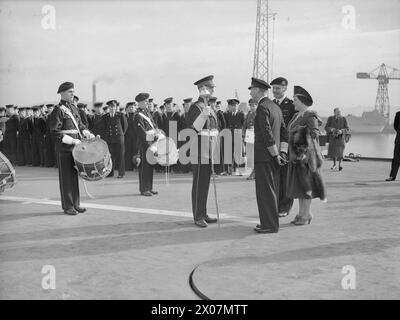 DIE ROYAL NAVY WÄHREND DES ZWEITEN WELTKRIEGS - HM King George VI. Sprach mit Bandmaster Camfield, RN, aus Dunoon, während der Inspektion an Bord der HMS INPLACABLE auf der HM Dockyard Rosyth. Royal Marine Trommler stehen hinter dem Bandmeister George VI., King, Royal Navy, INPLACABLE (HMS), Royal Navy, Royal Marines Band Service Stockfoto