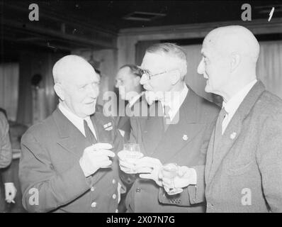 DORCHESTER DINNER FÜR FÄHRBESATZUNGEN. 17. AUGUST 1943, DORCHESTER HOTEL, LONDON. EIN ABENDESSEN FÜR BRITISCHE FÄHRBESATZUNGEN, DAS SIND EINIGE DER MÄNNER VON 17 BIS 70, DIE ALS FREIWILLIGE SEELEUTE UNTER DER ADMIRALITÄT DIE RUNNER CREWS DES KLEINEN SCHIFFES BEREITSTELLEN. - Von links nach rechts: Captain Owen Morewood (späte ägyptische Marine), Donald Cree (Secretary Royal Cruising Club) und E Campbell Muir (Ingenieur) Stockfoto