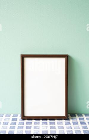 Bilderrahmen aus Holz auf blauem Fliesenregal. Mint. Wandhintergrund. Kopierbereich Stockfoto