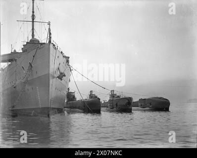 DAS U-BOOT THUNDERBOLT, EHEMALS HMS THETIS, KEHRTE NACH EINER PATROUILLE NACH HARBOUR ZURÜCK. 1940. - Die HMS THUNDERBOLT (rechts) legt mit anderen U-Booten neben ihrem Depot-Schiff an Stockfoto