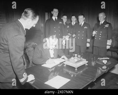 ADMIRALTY'S ABSCHIEDSESSEN FÜR ADMIRAL STARK. 13. AUGUST 1945, ROYAL MARINEKOLLEG GREENWICH. DAS ABSCHIEDSESSEN AN ADMIRAL H R STARK, USN, VOM VORSTAND DER ADMIRALITÄT. - Mr. Ernest Bevin, der Außenminister unterschreibt das Besucherbuch, als Commodore A W S Agar, VC, DSO, Captain und Präsident des Kollegiums zuschauen Stockfoto