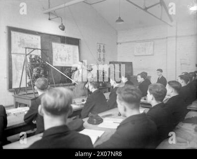 MÄNNER FÜR DIE FLOTTENLUFTWAFFE FÜR DIE ZUKUNFT. 15. UND 16. DEZEMBER 1943, ROYAL AIR TRAINING ESTABLISHMENT, NEWCASTLE-UNDER-LYME. JUNGE BRITEN, DIE SICH AUF EINEN WICHTIGEN JOB VORBEREITEN, JUNGEN AB 15 JAHREN, DIE FÜR DIE FLOTTENFLUGWAFFE TRAINIEREN. - Fluglehrer der Ingenieurabteilung in einem der vielen Klassenzimmer Stockfoto