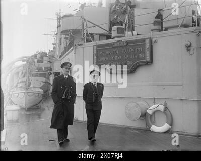 DIE NORWEGISCHE KÖNIGSFAMILIE WÄHREND DES ZWEITEN WELTKRIEGS - HM König Haakon von Norwegen ging mit Vizeadmiral McGrigor auf dem Quartierdeck der HMS NORFOLK während der Rückkehr der Königsfamilie nach Oslo am Ende des Krieges. Die königliche Familie floh aus Norwegen nach der deutschen Invasion Haakon VII., König von Norwegen, Royal Navy, NORFOLK (HMS) Stockfoto