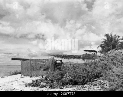 MARINES VERSTÄRKEN GEHEIME TROPISCHE ANKERPLÄTZE. 1944, ADDU ATOLL, MALEDIVEN. DIE DREIECKIGE GRUPPE VON KORALLENBUCHTEN AUF DEN MALEDIVEN, DIE TROTZ DER BENACHTEILIGUNGEN DURCH KRANKHEIT UND DSCHUNGEL HEIMLICH ALS ANKERPLATZ FÜR SCHIFFE BEFESTIGT WURDEN, DIE DIE WEITEN GEBIETE DES INDISCHEN OZEANS ÜBERQUERTEN, DIE IM SEPTEMBER 1941 VON DEN ROYAL MARINES DORTHIN GESCHICKT WURDEN. - Eine der Batterien, die von den Marines in Gan montiert wurden Stockfoto