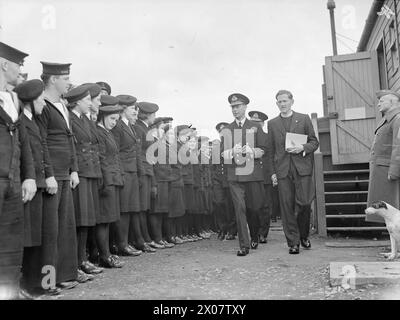 DER KÖNIG BESUCHT DIE HEIMATFLOTTE. 15. AUGUST 1943, SCAPA FLOW. DER KÖNIG BESUCHTE MÄNNER UND SCHIFFE DER HEIMATFLOTTE, ER GING AN BORD DES FLOTTENFÜHRERS HMS ONSLOW, DER IHN ZUM FLAGGSCHIFF HMS DUKE OF YORK BRACHTE. HIER TRAF DER KÖNIG AUF ADMIRAL SIR BRUCE A FRASER, KBE, CB, C-IN-C-FLOTTE. - Der König verlässt die Hütte der Church of Scotland, beobachtet von Mitgliedern der WRNS Stockfoto