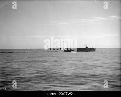 NÄCHTLICHER ANGRIFF AUF FEINDLICHEN KONVOI; MARINEAUFNAHMEN. AM 12. JANUAR 1945 AN BORD DES KREUZERS HMS NORFOLK WÄHREND DES ERFOLGREICHEN ANGRIFFS VON SCHIFFEN DER HEIMATFLOTTE AUF EINEN FEINDLICHEN KONVOI, DER WICHTIGE KRIEGSVORRÄTE VOR DER KÜSTE NORWEGENS TRANSPORTIERTE. DER KONVOI WURDE FAST VOLLSTÄNDIG ZERSTÖRT. - Britische Escort-Träger PREMIER (nächstgelegen) und TROMPETER, die Jagdschutz boten. Ein feindliches Flugzeug wurde abgeschossen Stockfoto