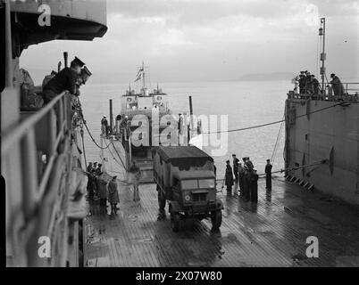 DIE ROYAL NAVY WÄHREND DES ZWEITEN WELTKRIEGS – an Bord der HMS EASTWAY, dem ersten Anlegeplatz, werden 3-Tonnen-LKWs von LCT (3) 466, vor der Küste der Greenock Royal Navy, EASTWAY (HMS), Royal Navy, LCT 466, ausgehängt Stockfoto