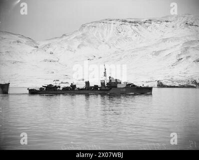 AN BORD DER HMS SIEGREICH. 23. BIS 28. JANUAR 1942 AN BORD DES FLUGZEUGTRÄGERS IN HVALFJORD, ISLAND. HMS VICTORIOUS UND ANDERE SCHIFFE DER FLOTTE PATROUILLIEREN IM NORDATLANTIK AUF DER SUCHE NACH DEM DEUTSCHEN SCHLACHTSCHIFF TIRPITZ. - Der britische Zerstörer HMS INTREPID kommt nach Hvalfjord vor der Patrouille Royal Navy, HMS Intrepid, Destroyer, (1936) Stockfoto