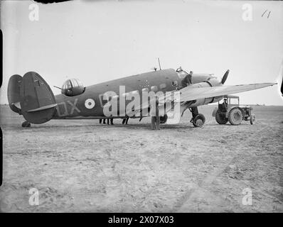 ROYAL AIR FORCE COASTAL COMMAND, 1939-1945. - Die Groundcrew untersucht einen schwer beschädigten Lockheed Hudson Mark I, N7264 'QX-Q', von der No. 224 Squadron RAF, nach seiner Rückkehr nach Wick, Caithness, von einem Angriff über Norwegen. N7264 war einer von drei Hudsons, die den alliierten Truppen in Norwegen Langstreckenjäger zur Deckung brachten. Beim Flug über den Romsdal-Fjord in Andalsnes wurden sie versehentlich von der HMS CURACOA beschossen. Ein Hudson wurde abgeschossen und N7264 erlitt schwere Schäden an den Flügeln und Klappen sowie zwei geplatzte Reifen. Trotzdem gelang es Pilot Officer H O’Neill, sein Flugzeug zurückzubringen Stockfoto