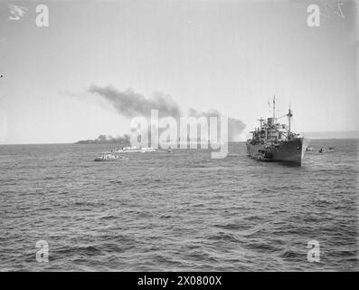 Während der Operation Husky am 9-10. Juli 1943 näherte sich die Invasionsflotte Sizilien an, um Truppen, Panzer und Geschütze zu landen. Die HMS Glengyle senkte ein LCVP, während ein Landungsboot in der Ferne brannte. Stockfoto