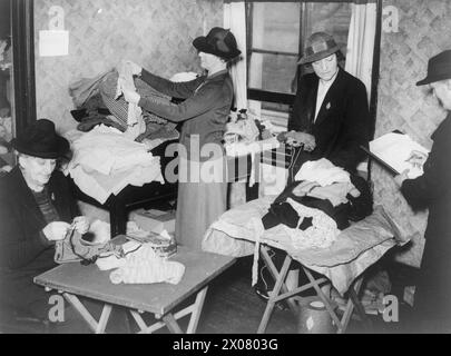 DIE ARBEIT DES CITIZENS' ADVICE BUREAU, ELDON HOUSE, CROYDON, ENGLAND, 1940 - Kleidung wird von weiblichen Freiwilligen der Personal Service League beim Citizens' Advice Bureau in Croydon sortiert. Diese Kleidung würde an Bedürftige in der Umgebung verteilt Stockfoto