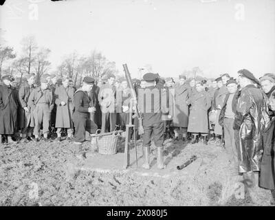 DEMS-SCHÜTZEN HALTEN PACE MIT DEN NEUESTEN KRIEGSWAFFEN. 11. UND 12. NOVEMBER 1943, DEMS RANGES, CARDIFF. DAS DEMS-TRAININGSZENTRUM, IN DEM DIE MÄNNER, DIE FEINDLICHE SEE- UND LUFTANGRIFFE AUF ALLIIERTE HANDELSSCHIFFE ABWEHREN, AUFFRISCHUNGSKURSE ABSOLVIEREN, UM PACE MIT IHREN NEUEN VERTEIDIGUNGSWAFFEN ZU VERSORGEN. - Der Wert der Tracerkugel, die demonstriert wird. Zuhören und zuschauen sind Männer aus Holland, Norwegen, Amerika und England. Der Kumpel des Chief Gunner CPO C F H Pitman feuert und gibt Ratschläge für die DEMS-Bewertung Stockfoto