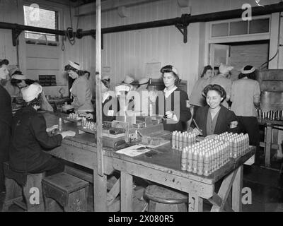 LEBEN IM ROYAL NAVY ARMAMENT DEPOT PRIDDY's HARD, GOSPORT, 25-30. JULI 1944 - bei RNAD Priddy's Hard, Gosport, werden zwei-Pfünder-Granaten schließlich von einem Inspection Girl gewogen, bevor sie für den Einsatz in der SEA Royal Navy freigegeben werden Stockfoto