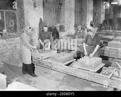 MÄNNER UND FRAUEN HINTER GROSSBRITANNIENS SCHIFFEN. MAI 1945, ALSTON FOUNDRY, ALSTON, CUMBERLAND. - Frauen machen Formen für Kettenglieder. Mädchen machen Formen für Kettenglieder Alston Foundry Stockfoto